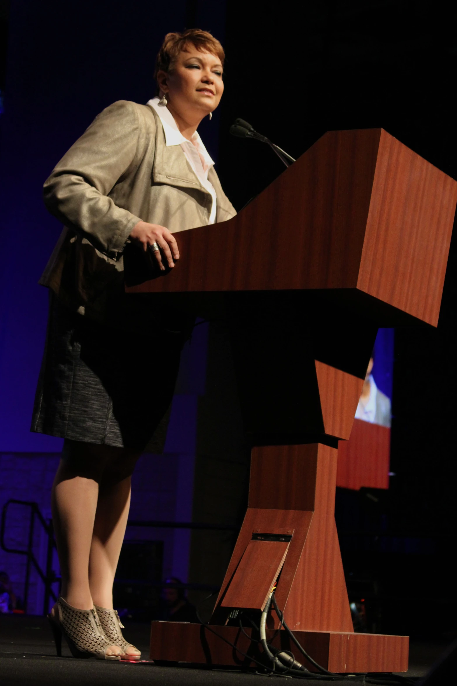 a woman in heels stands at a podium