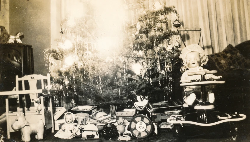 black and white pograph of stuffed animals with christmas tree in background