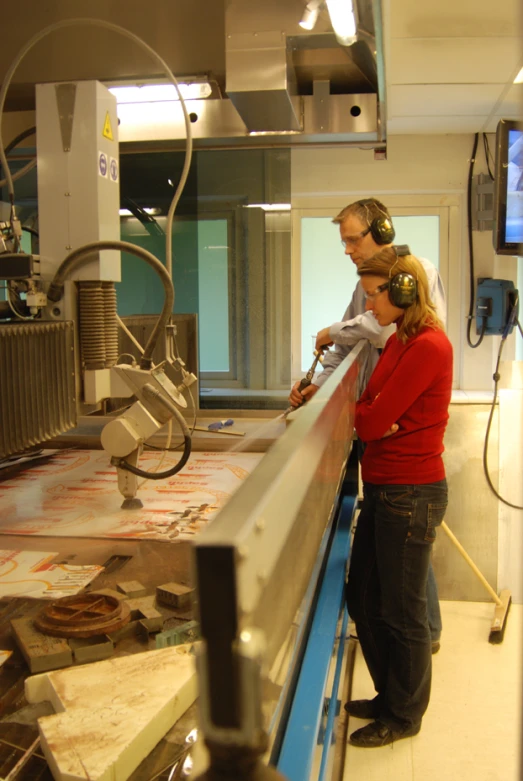 a man and woman are using an automated machine