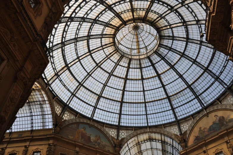 an ornate domed glass ceiling in the center of a mall