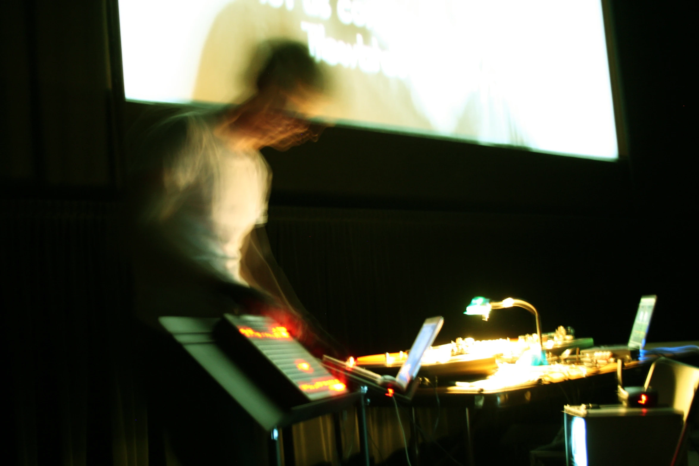 a guy standing in front of a screen holding a keyboard