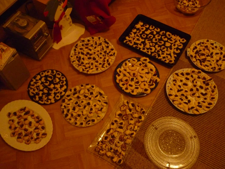 pizzas on trays and plates, ready for baking