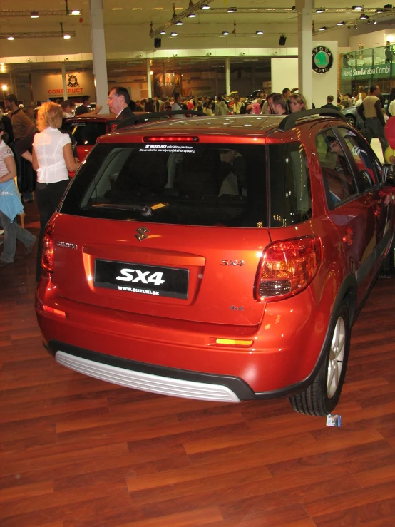 a car parked in an auto show and people looking at it