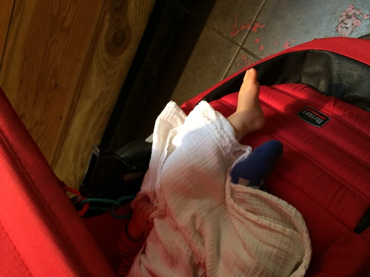 a baby laying in the top of an open luggage bag