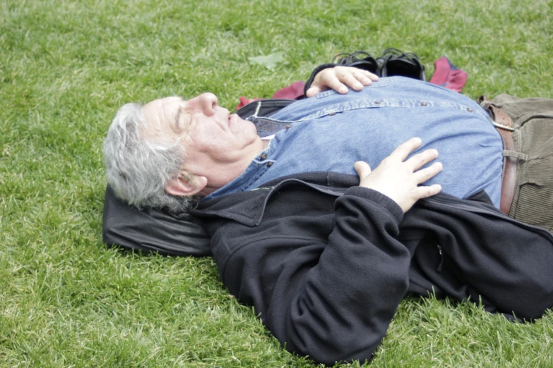 a man is laying on the grass playing with a frisbee