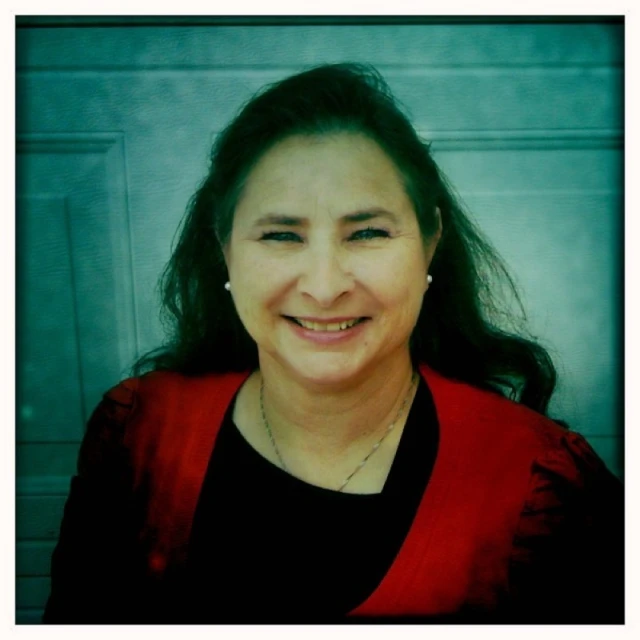 a woman smiling for the camera in front of a door