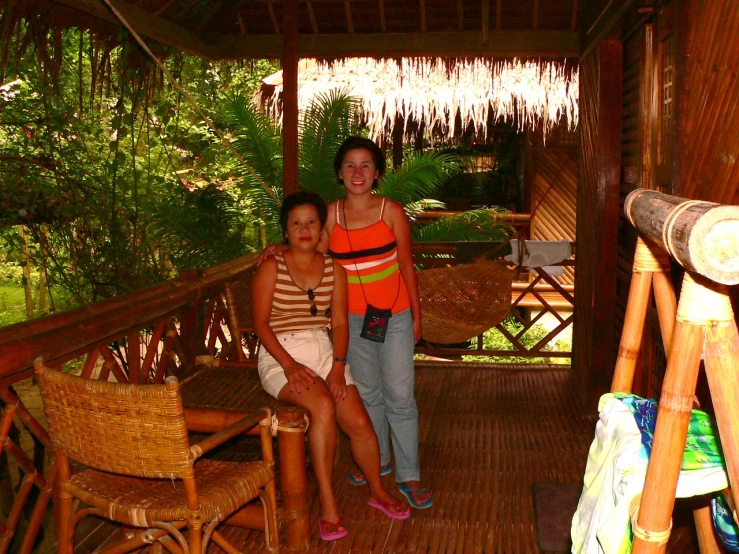 two women that are sitting on a porch together