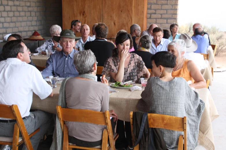 people are sitting at the table with food