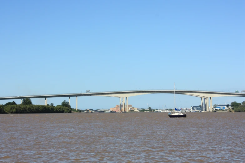 a boat sitting in a body of water under a bridge