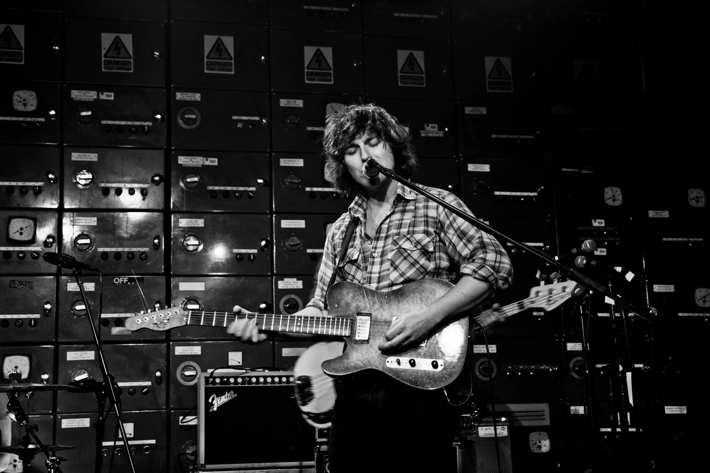 a man is playing an electric guitar in front of sound equipment