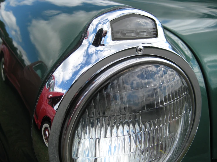 the lights on an old fashioned green car