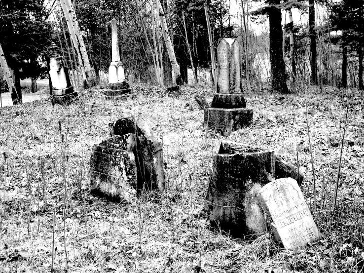 graveyard scene in the dark, a ghost figure is pictured next to a grave