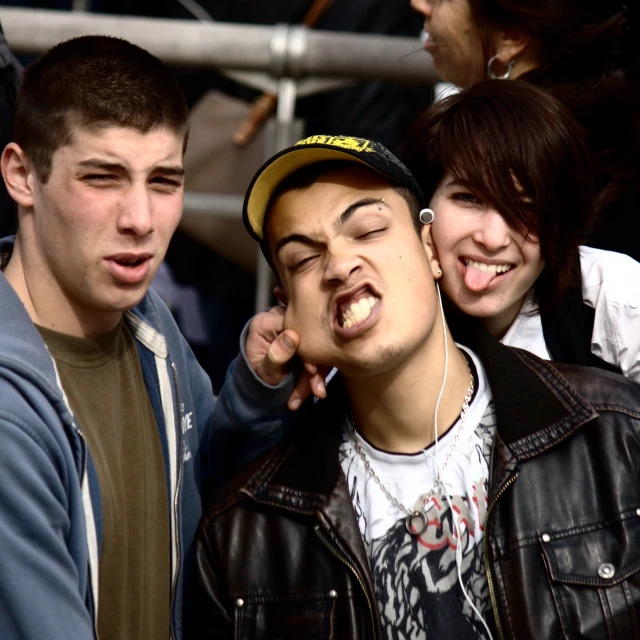 a young man wearing headphones stands beside a group of smiling young people