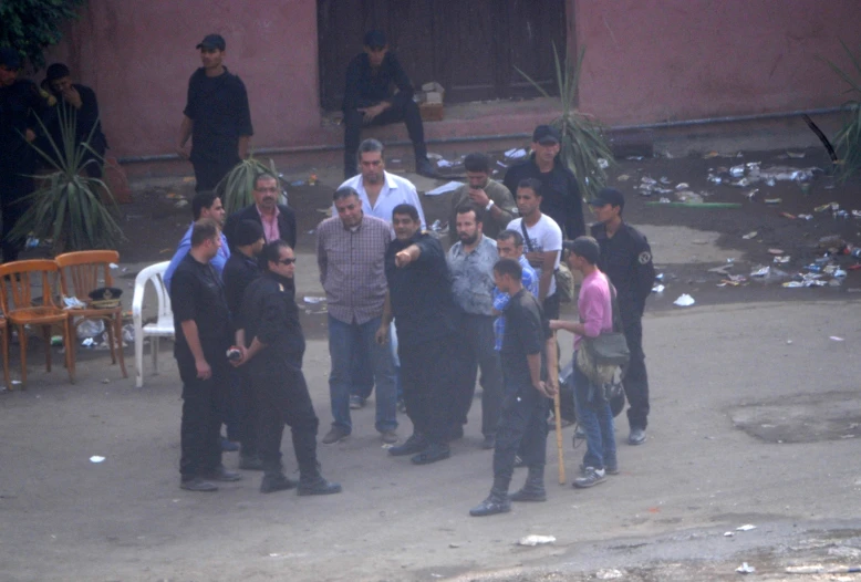 a group of men standing around in front of a building