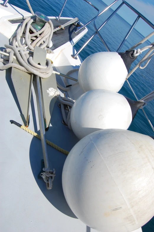 three large white balls sit on the bow of a ship