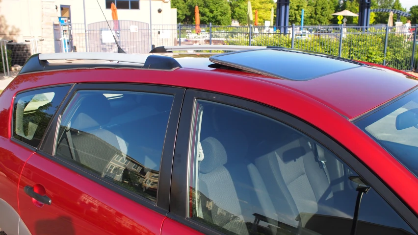 the back end of a red car with a luggage rack on top