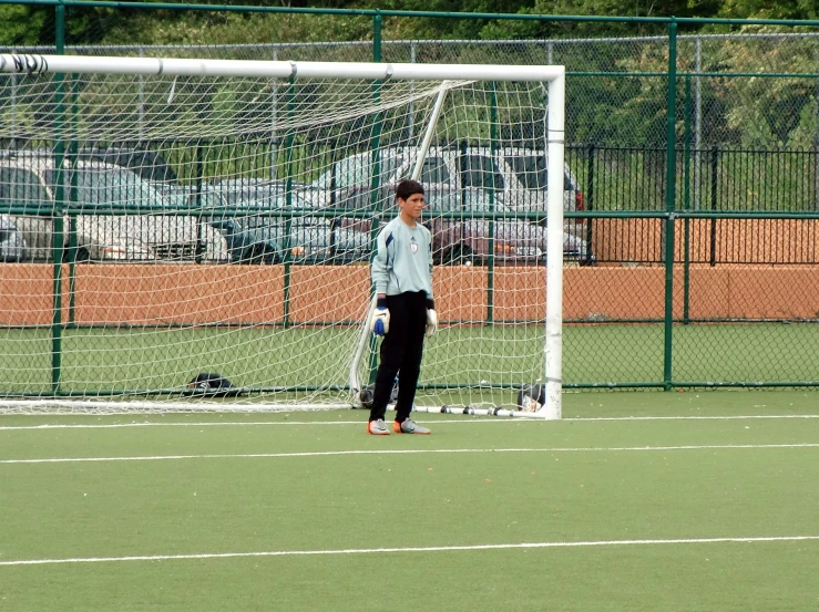 a man standing next to a goal net