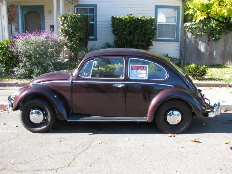 an old brown car parked on the side of a street