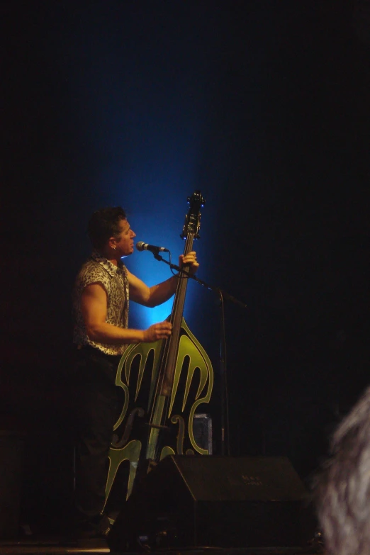 a musician on stage with a guitar in front of him