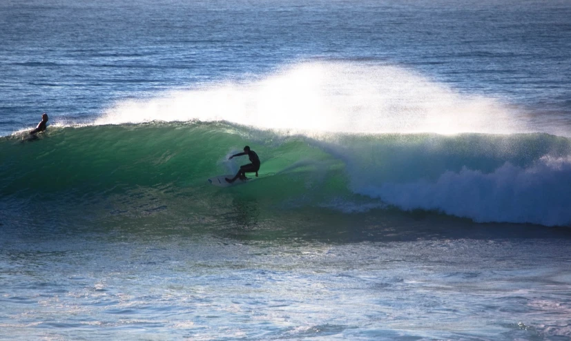 surfer on large ocean wave with person riding top