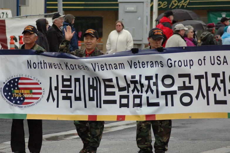 a group of asian men holding up a banner