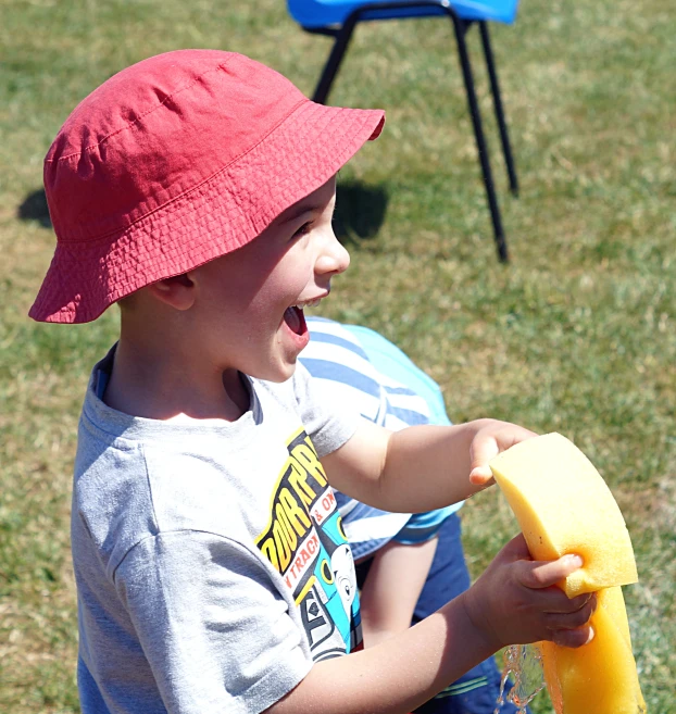 the boy smiles while holding a plastic tube