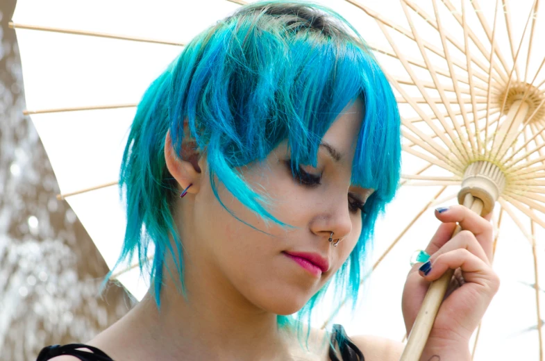 a woman with blue hair holding a parasol