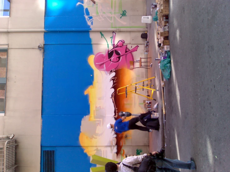 some people painting on a building with colored paint