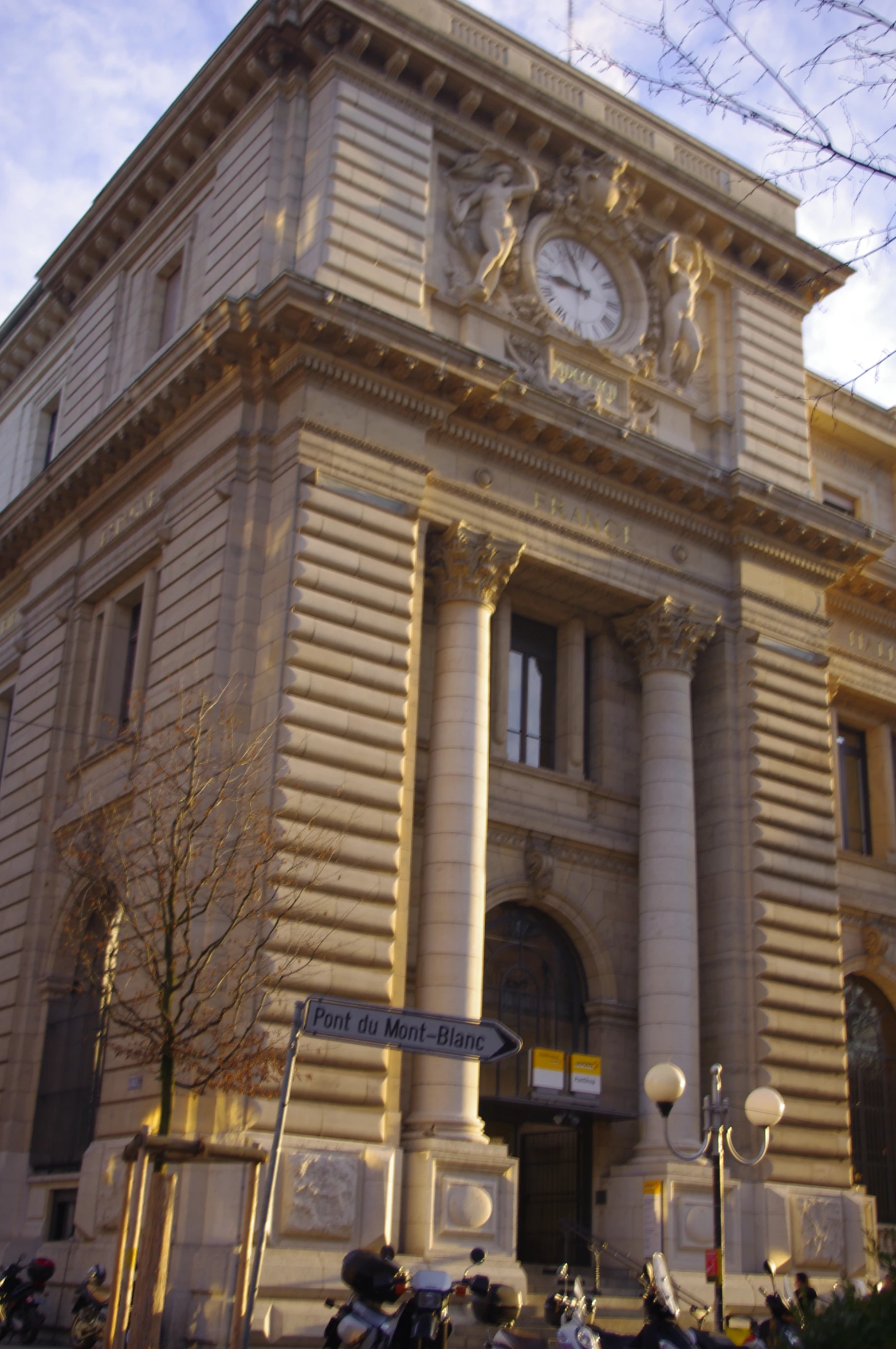 motorcycles are parked in front of a large building with a clock