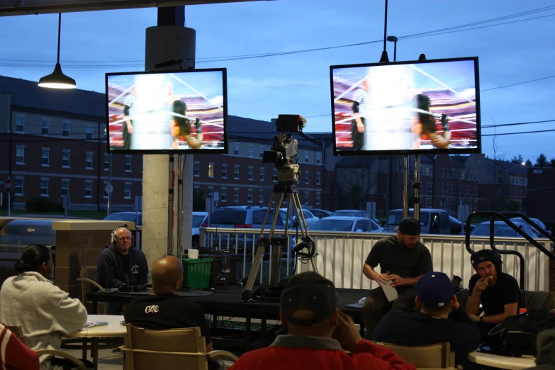 people sitting in chairs and watching tvs with cameras