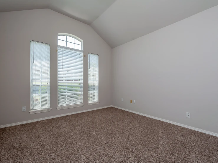 a room with a large window with white curtains