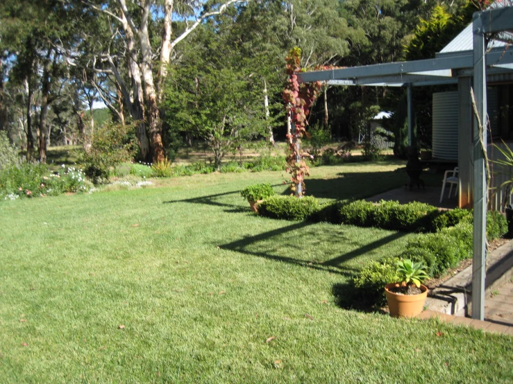 a patio and yard with green grass and shrubbery