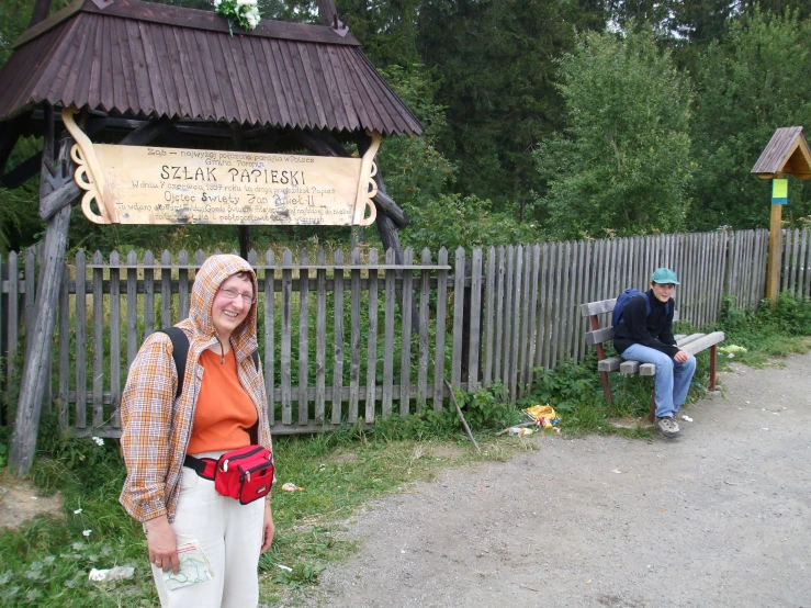 two people on bench at a small wooden building