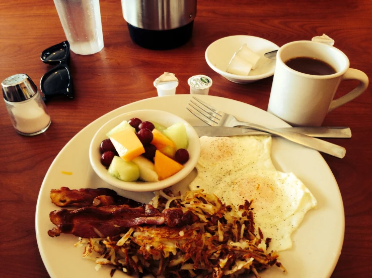 a plate with breakfast food and coffee on a table