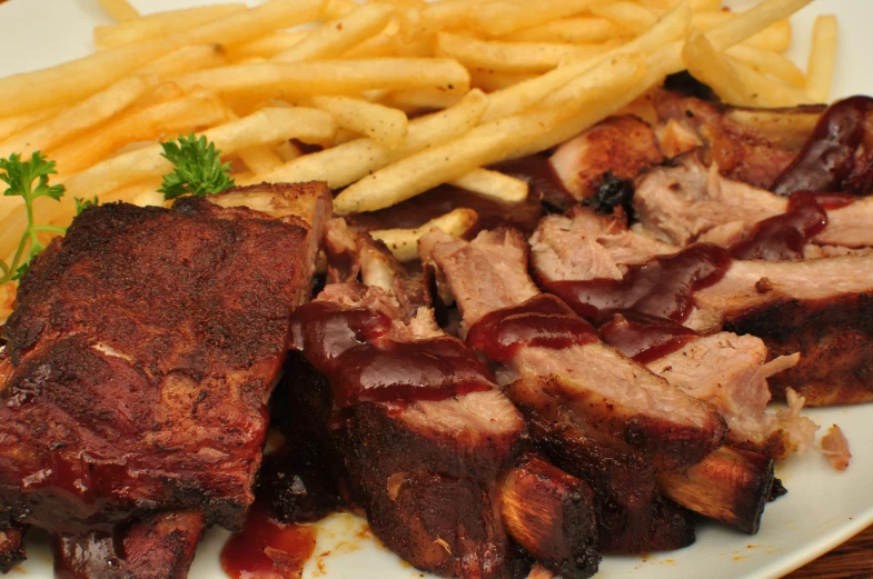 a plate topped with meat and fries covered in ketchup