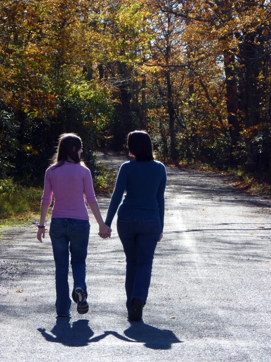 two people walking holding hands down the road