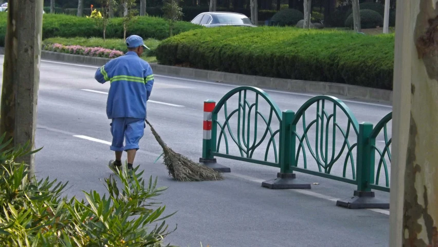 a man sweeping the road with a broom