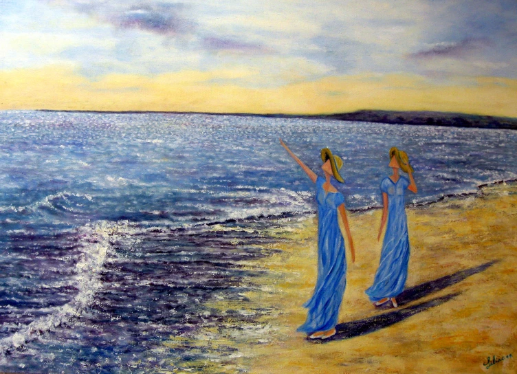 two women in blue are walking on the beach