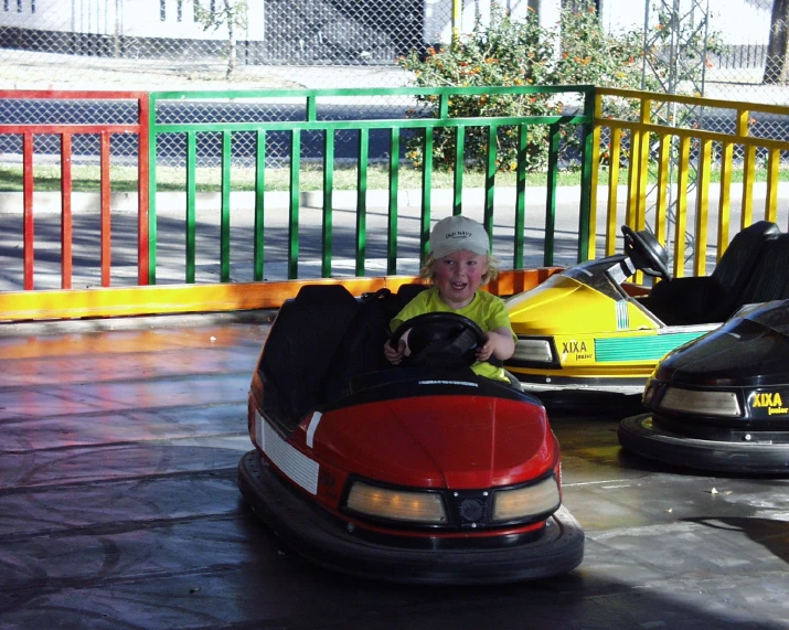 a boy riding an bumper car in a carnival ride