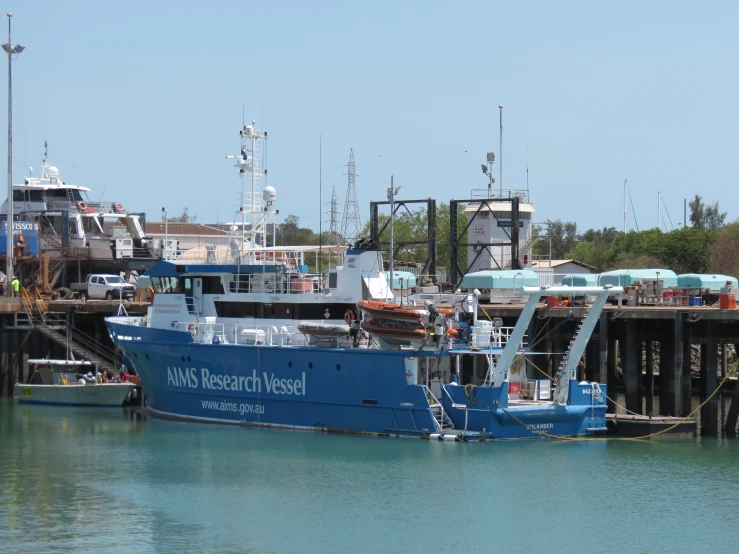 a boat parked at the dock with another in the water