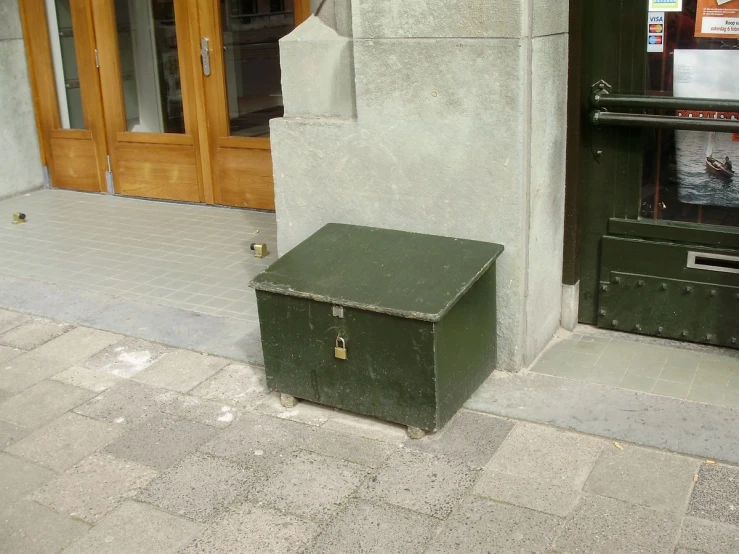 green chest of drawers outside of gray building