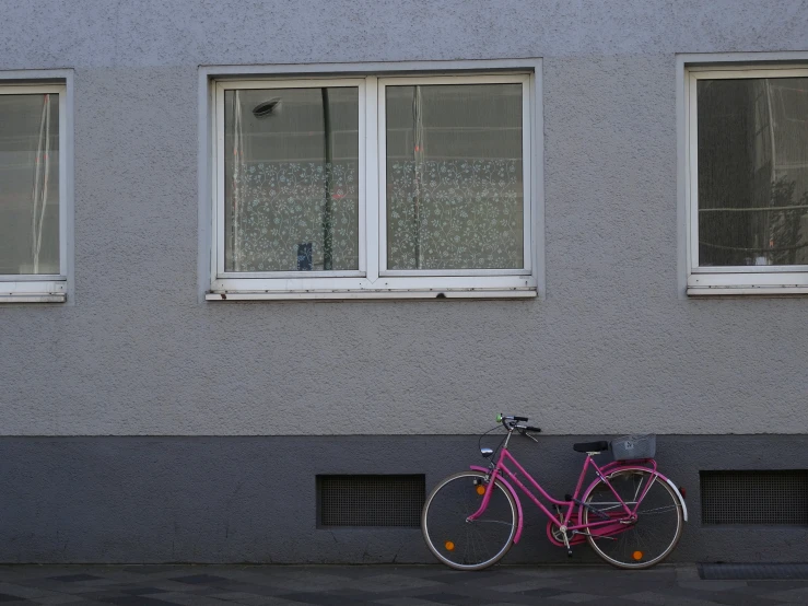the bike is parked in front of two windows