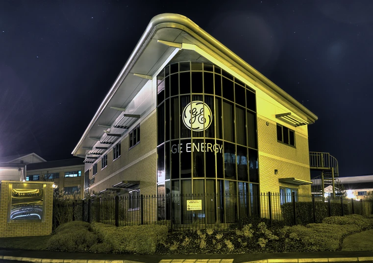 a big yellow building on a street by night