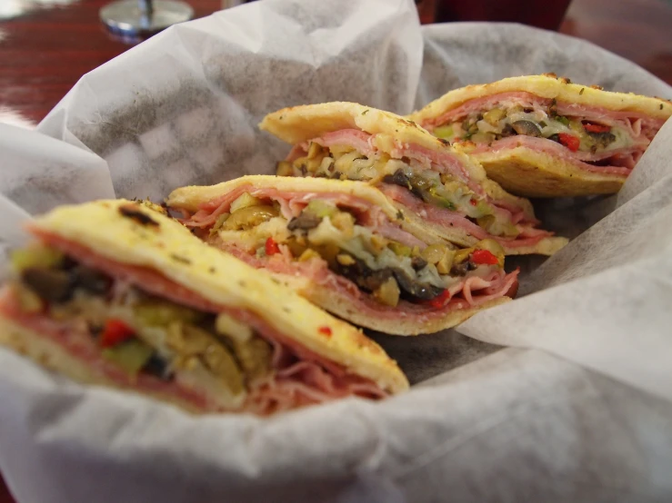 there are three sandwiches sitting on top of a napkin