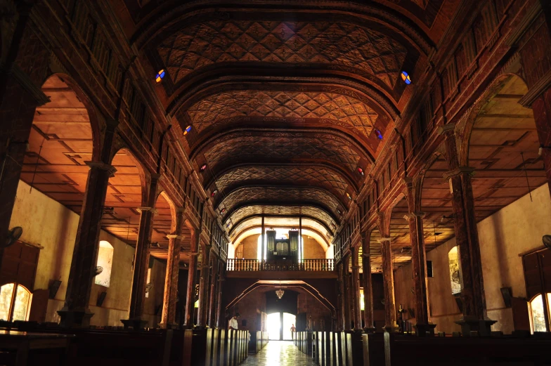 an empty cathedral that has a wood ceiling and large columns