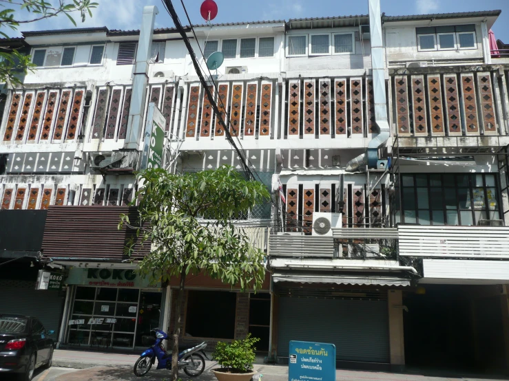 a tall building with wooden windows next to a tree