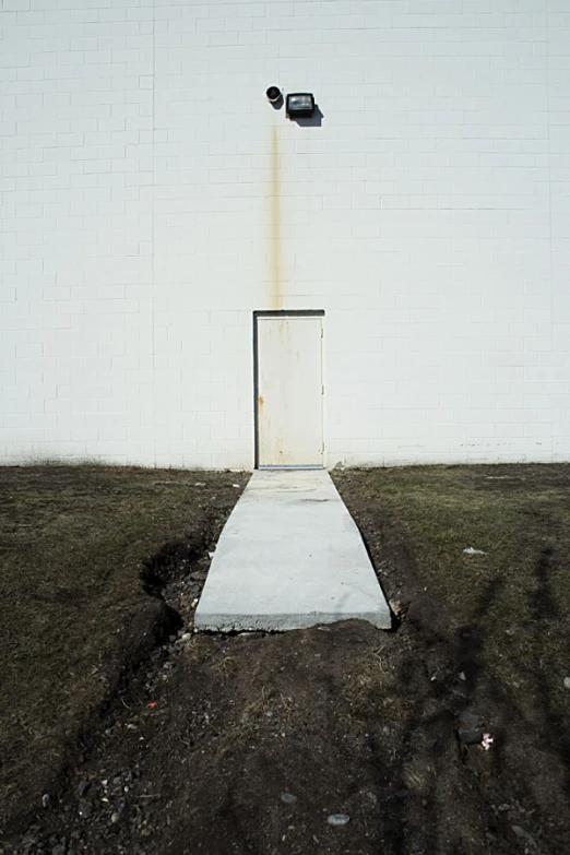 a white door to a grassy area under a street light