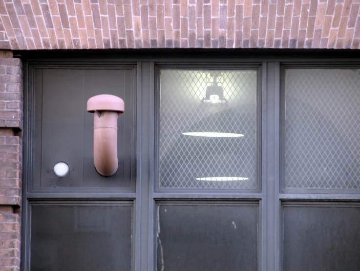 an object hangs on a building window next to the door