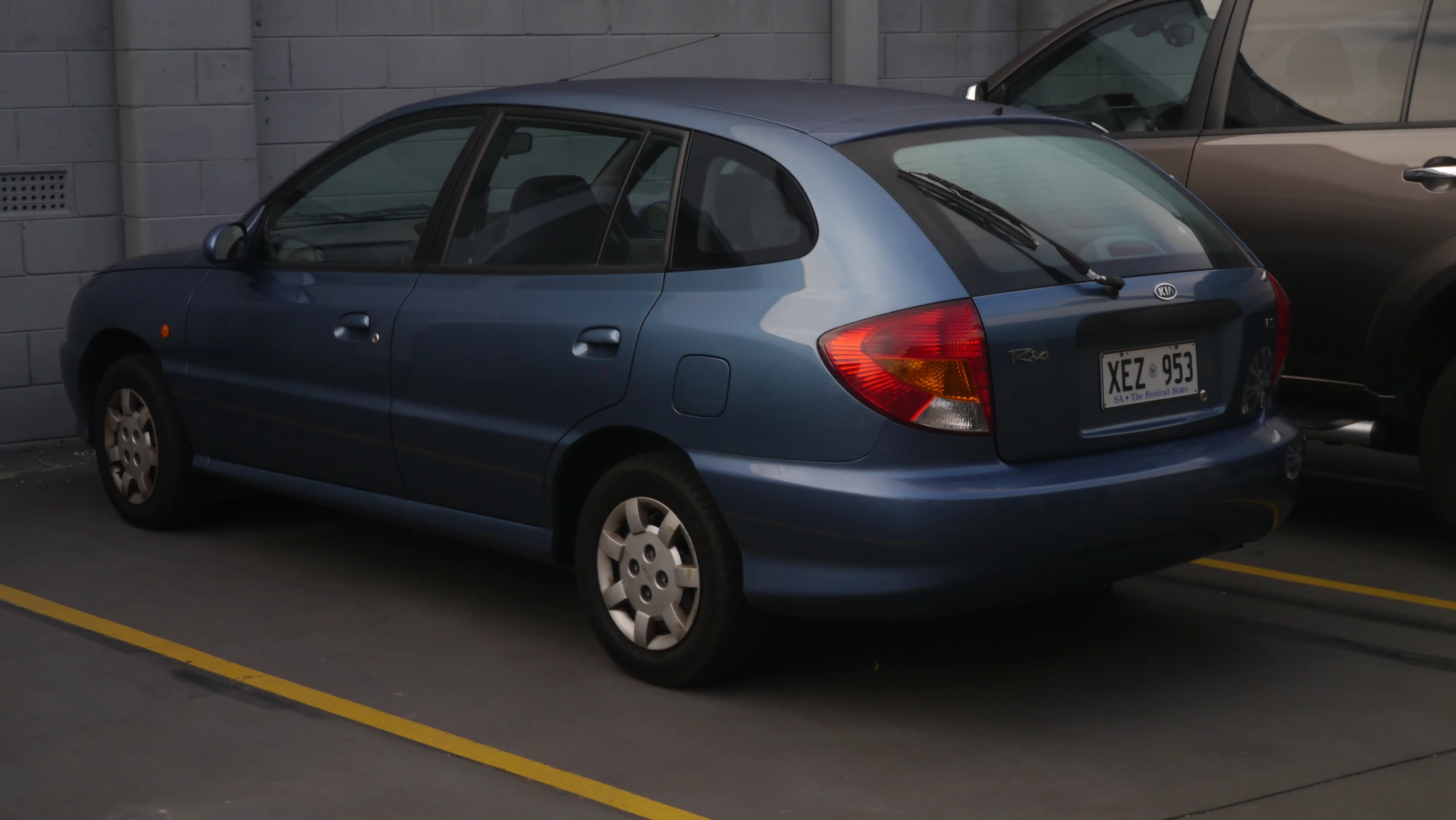 a small blue hatchback parked next to a smaller one