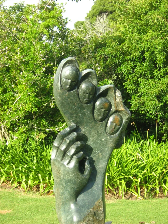 a large statue holding his hands together in a garden